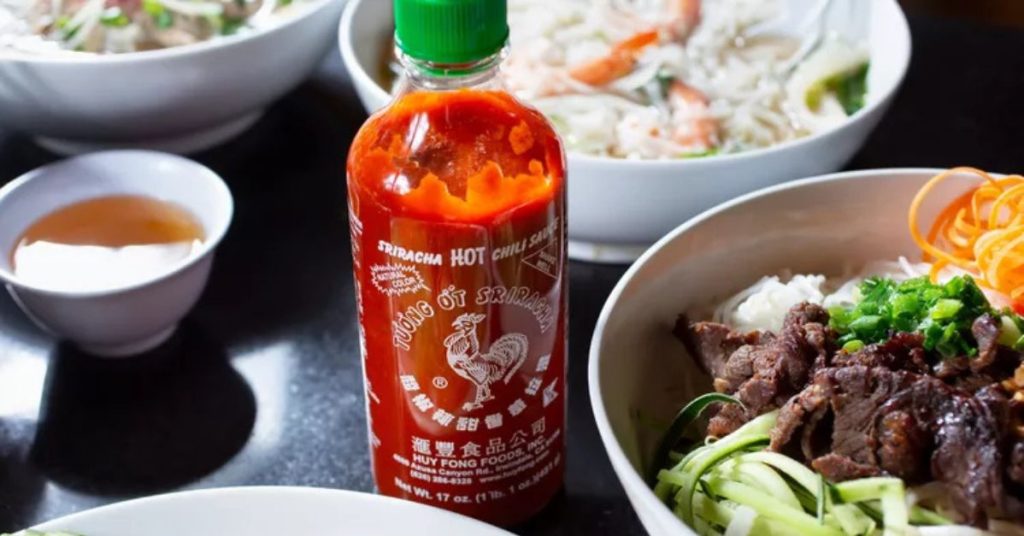 what is a sriracha – sriracha sauce next to noodle bowl